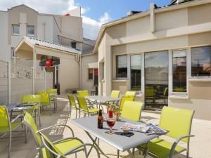 d'une terrasse avec des tables et des chaises jaunes. dans l'établissement Ibis Le Havre Sud Harfleur, à Harfleur