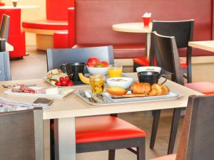 einen Tisch mit einem Tablett mit Frühstückszutaten darauf in der Unterkunft Ibis Le Havre Sud Harfleur in Harfleur