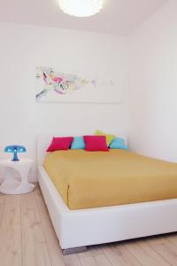 a white bed with colorful pillows in a bedroom at Zebra Baltic in Świnoujście
