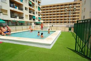 a group of people in a swimming pool in a building at PeñiscolaPlaya Orangecosta in Peniscola