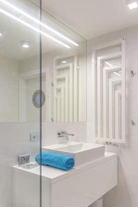 a white bathroom with a sink and a mirror at Zebra Baltic in Świnoujście