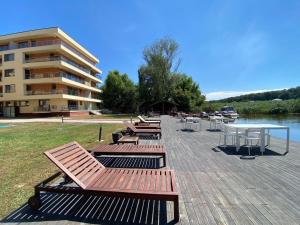 a group of benches and a table and a building at Skyline Snagov Lake Apartments - Club Lac Snagov in Turbaţi