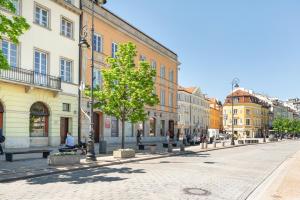 a street in a city with people sitting on benches at Warsaw Premium Apartment President Palace in Warsaw