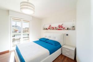 - une chambre avec un lit blanc et des oreillers bleus dans l'établissement LA RESIDENCIA, à Alghero