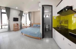 een slaapkamer met een bed en een keuken met een wastafel bij Duc Hanh Apartment in Da Nang