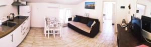 a kitchen and a living room with a couch and a table at Appartements Dominique, with private terrace in Supetarska Draga
