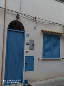 カステッランマーレ・デル・ゴルフォにあるCasetta Dei Pescatoriの青いドアと窓が2つある建物