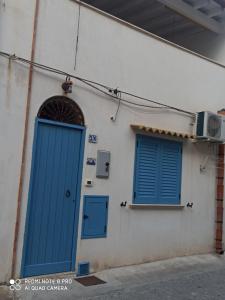カステッランマーレ・デル・ゴルフォにあるCasetta Dei Pescatoriの青いドアと窓が2つある建物