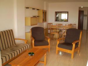 ein Wohnzimmer mit einem Sofa, Stühlen und einem Tisch in der Unterkunft Peñiscola Azahar vistamar Superior Orangecosta in Peñíscola