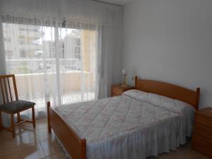 ein Schlafzimmer mit einem Bett, einem Fenster und einem Stuhl in der Unterkunft Peñiscola Azahar vistamar Superior Orangecosta in Peñíscola