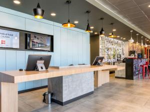 a lobby of a restaurant with two desks with laptops at ibis Calama in Calama