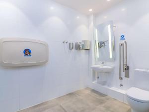 a white bathroom with a toilet and a sink at ibis Calama in Calama