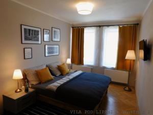 Un dormitorio con una cama con almohadas amarillas y una ventana en VILA POD LIPAMI, en Bruntál