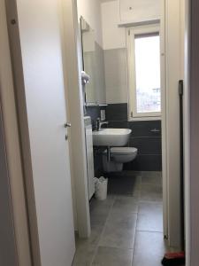 a bathroom with a sink and a toilet and a window at PeschieraView Flat x4 in Peschiera del Garda