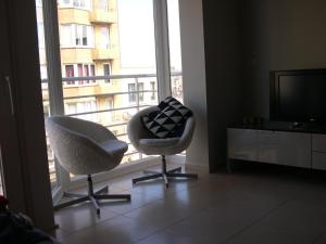 a living room with two chairs and a television at Appartement Koksijde in Koksijde