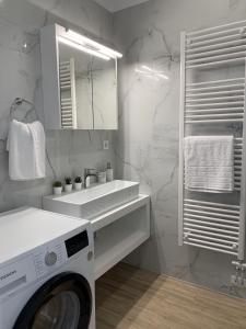 een witte badkamer met een wasmachine en een wastafel bij Leonidas House in Chania