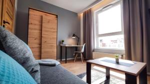 salon z kanapą, stołem i oknem w obiekcie Wrocławska Two Bedroom Apartment w Krakowie