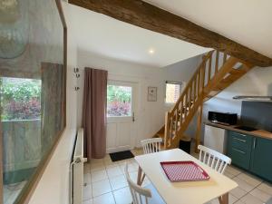a kitchen and a dining room with a table and chairs at Le Bien-Venant in Domvast