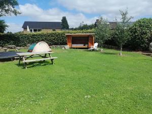 a picnic table and a tent in a yard at Shelter Slotsgaarden in Jels