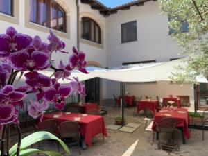 a patio with tables and chairs and purple orchids at La Crota Ristorante e Camere da Danilo dal 1983 in Roddi