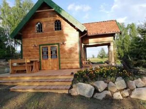 a small wooden building with a wooden deck at Domek letniskowy TONKA in Świątki