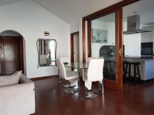 een woonkamer met een glazen tafel en witte stoelen bij VILLA FENIX in Puerto del Carmen