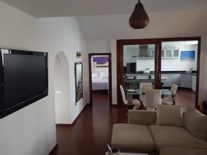 een woonkamer met een bank en een televisie bij VILLA FENIX in Puerto del Carmen