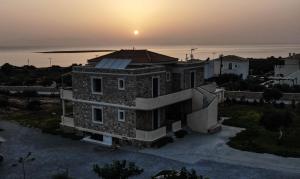 une maison avec un coucher de soleil en arrière-plan dans l'établissement Castro Elafonisos, à Elafonisos