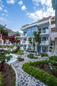 ein Apartmenthaus mit einem Garten und Blumen in der Unterkunft Kassandra Boutique Hotel in Oludeniz