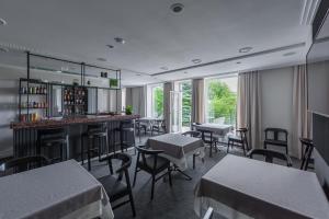 a restaurant with tables and chairs and a bar at Park Hotel Šiauliai in Šiauliai