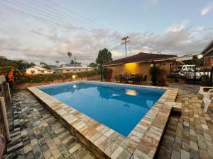 a swimming pool in a backyard with a table and chairs at Milgate Motel in Casino