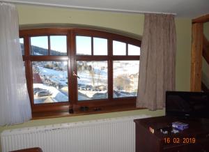 a large window with a view of a snow covered yard at Śnieżka in Duszniki Zdrój