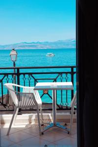 a table and chairs on a balcony overlooking the ocean at Hotel Kyani Akti in Xylokastro