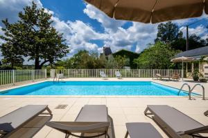 a swimming pool with chairs and an umbrella at Château Meyre in Avensan