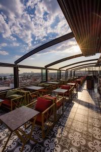 restauracja ze stołami i krzesłami na dachu budynku w obiekcie Grand Balyan Hotel & Restaurant w Stambule