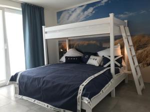 una camera con letto a castello e pareti blu di OceanView a Wittdün