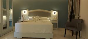 a bedroom with a white bed and a chair at Augusta Methoni Hotel in Methoni
