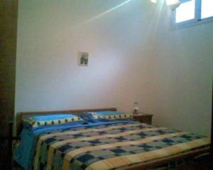 een slaapkamer met een bed met een blauwe en witte deken bij Casa vacanza Marina di Andrano zona Grotta Verde in Andrano