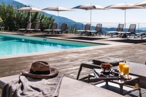 un cappello seduto su un tavolo accanto alla piscina di Villa Guinigi Dimora di Epoca Exclusive Residence & Pool a Lucca