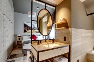 a bathroom with a sink and a mirror at Hotel Derby in Zermatt