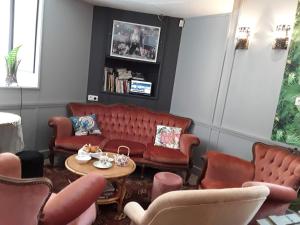 a waiting room with red couches and a table at Madelon IV in Belvès