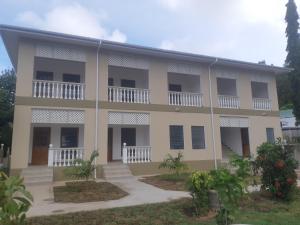 um grande edifício com varandas e um pátio em La Residence D'Almee Guesthouse em Praslin