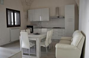 ウッジャーノ・ラ・キエーザにあるTerre Russeのキッチン(テーブル、白い椅子、テーブル、椅子付)