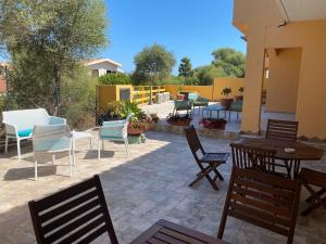 eine Terrasse mit Stühlen, Tischen und einem Tisch in der Unterkunft B&B Pettirosso in San Teodoro