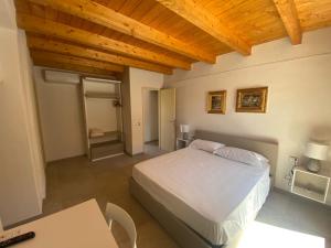 ein Schlafzimmer mit einem Bett und einer Holzdecke in der Unterkunft B&B Pettirosso in San Teodoro