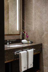 a bathroom with a sink and towels on a counter at Gardino Hotel & Residence in Riyadh