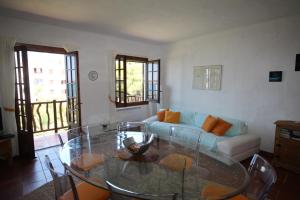un soggiorno con tavolo in vetro e divano di Casa Cristalina Menorca a Fornells