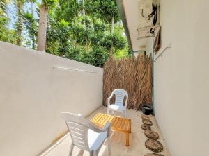 a patio with two chairs and a bench and a fence at Sunrise Inn in Thoddoo