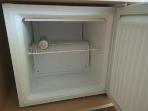 un réfrigérateur vide avec une horloge dans la porte dans l'établissement Simonhöhe Appartment with Swimmingpool, à Zirkitz