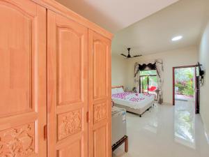 a bedroom with a bed and a large wooden cabinet at Sunrise Inn in Thoddoo